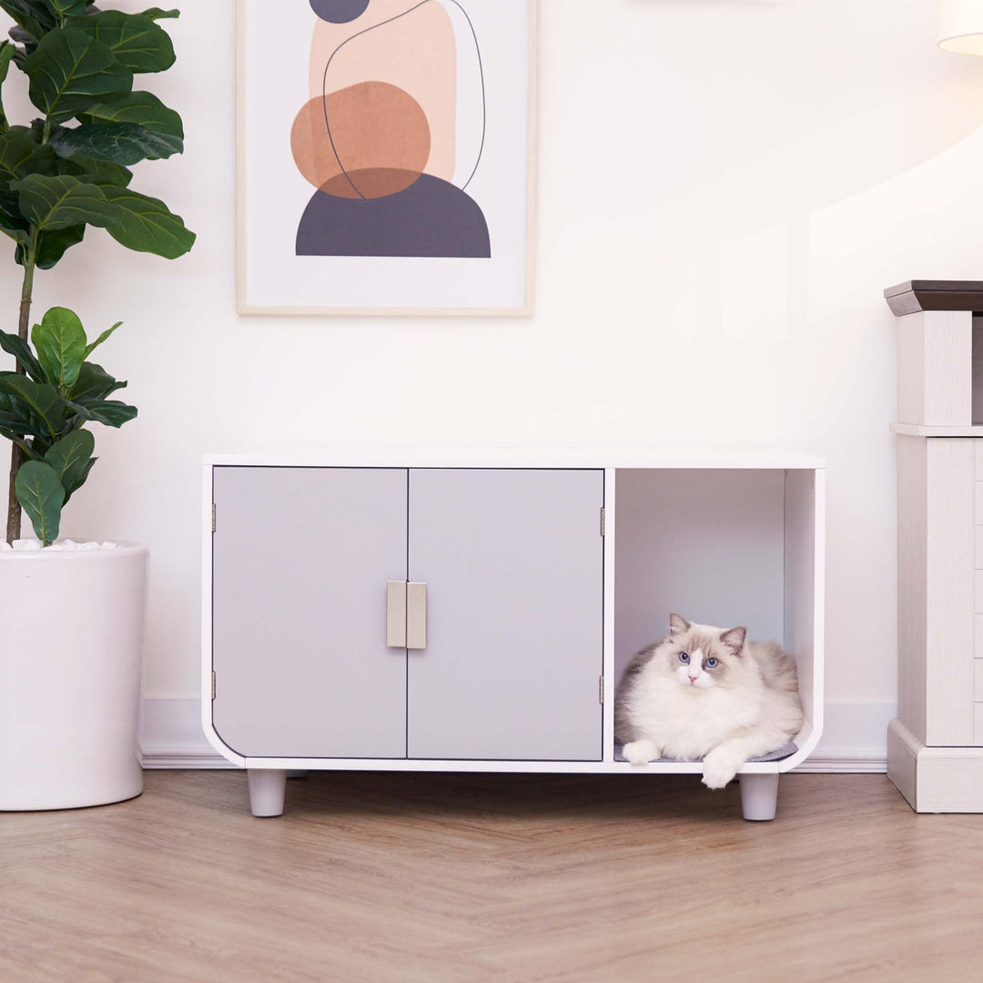 A white cat sitting inside the open section of the Dyad Wooden Cat Litter Box Enclosure and Side Table, Alpine White/Gray