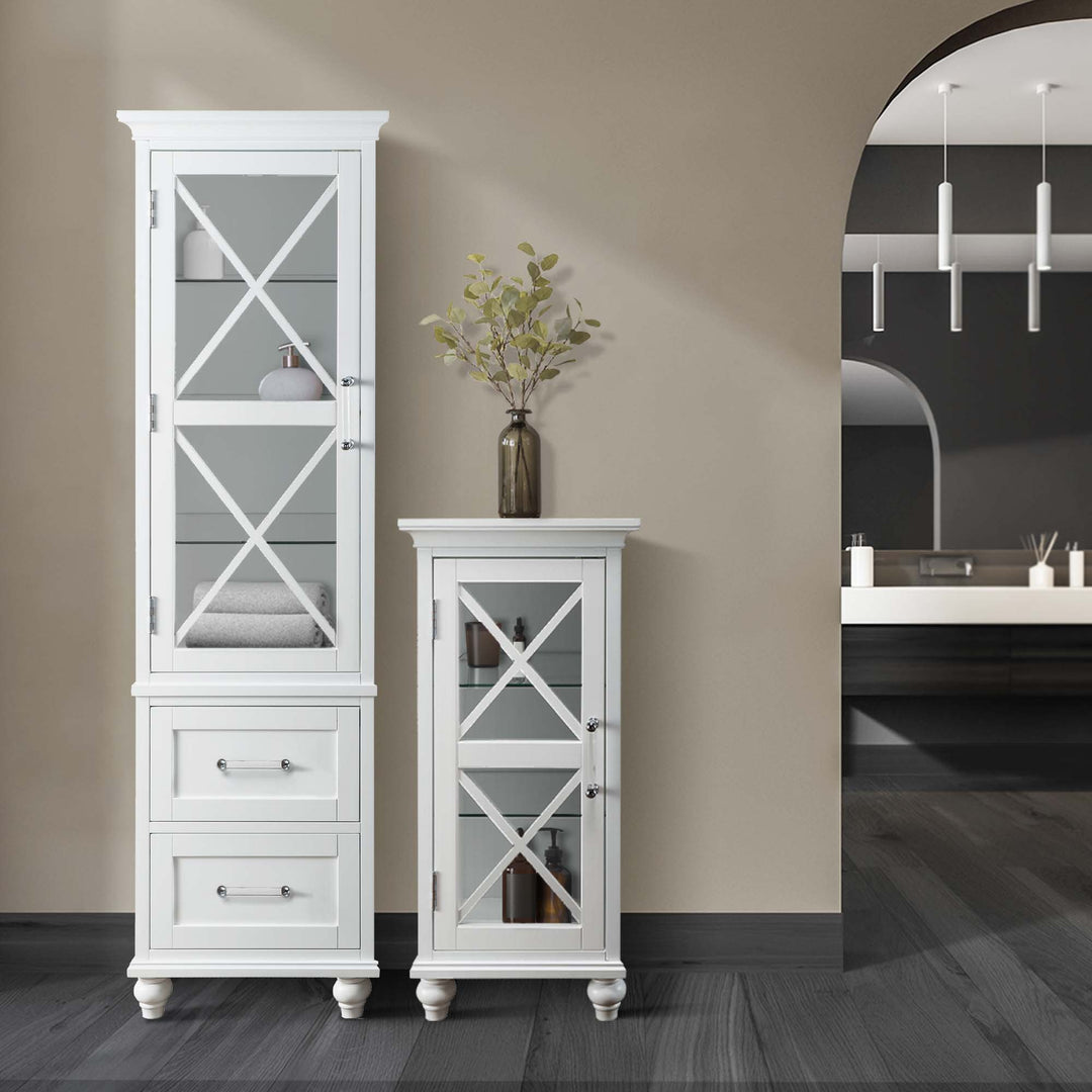 A tall Teamson Home Blue Ridge Wooden Linen Tower Cabinet with Adjustable Shelves, White with glass doors beside a shorter matching cabinet in a modern room with a view into a bathroom.