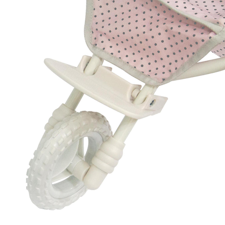 A close-up of the all-terrain white rubber wheel in the front of the baby doll stroller. 