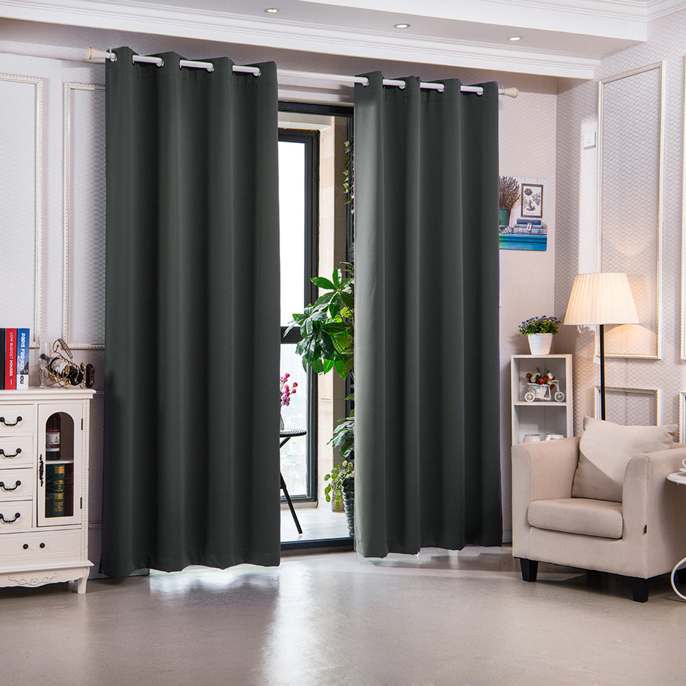 A well-lit room with dark Teamson Home 96" Delphi Premium Solid Insulated Thermal Blackout Window Curtain Panels with Grommets, Smoke Gray drawn closed, a cream-colored armchair, and a white Teamson sideboard with decorative items.