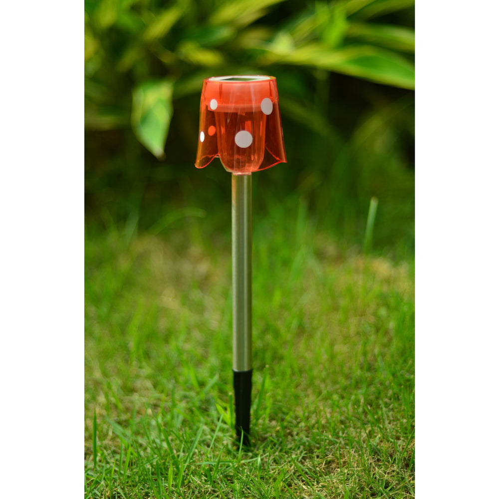 Teamson Home Mini Solar Stake Light, red with white polka dots, with the ground spike planted in the grass