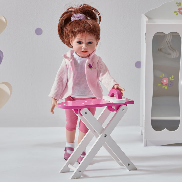 A doll is standing in front of Olivia's Little World Little Princess Wooden Doll Ironing Board and Iron, ready for pretend play.