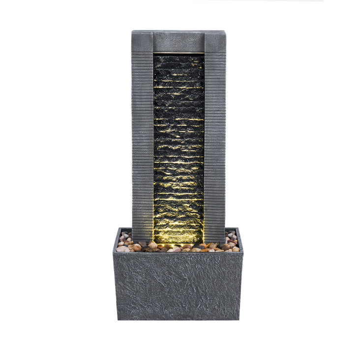 A Teamson Home Demeter Outdoor Water Fountain with a textured cascade and pebble accents, illuminated from the bottom