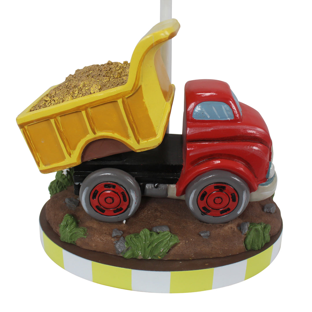 Close up of the dump truck on the base with the red cab, yellow dump body with dirt inside, and the rugged base underneath the truck.