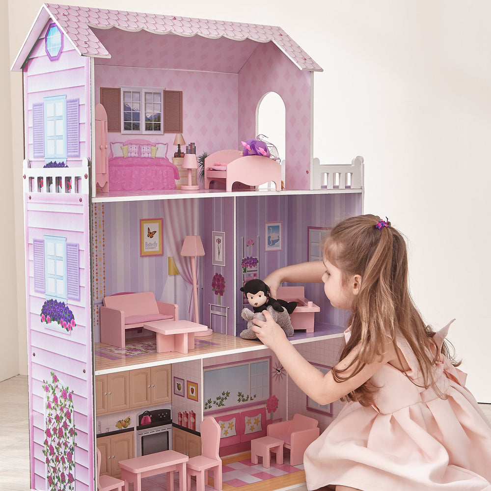 A little girl playing with Olivia's Little World Dreamland Tiffany Dollhouse with 12 Accessories, Pink/Purple.