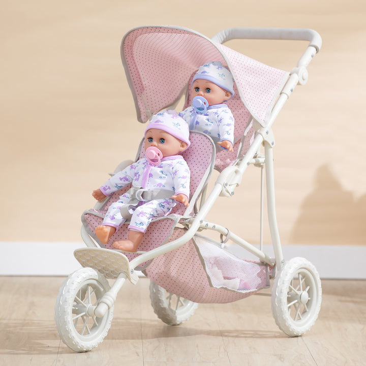 Two baby dolls sitting in the Olivia's Little World Polka Dots Princess Double Jogging Stroller for Dolls, Pink with gray polka dots