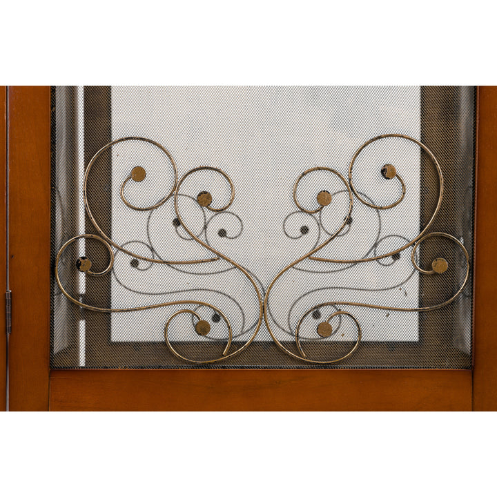 A close-up of the ornamental scrollwork against the screened panel.