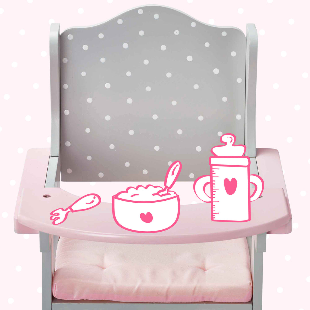 A pink and grey with white polka dots baby doll high chair with illustrations of a bottle, cereal and a fork on the tray.