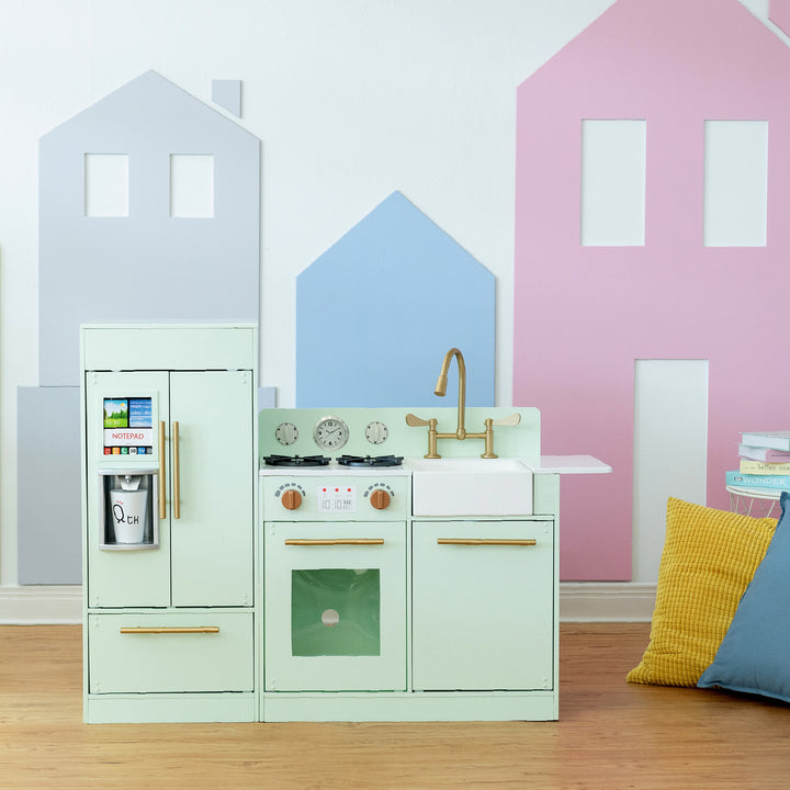 A Teamson Kids Little Chef Charlotte Modern Play Kitchen, Mint/Gold with realistic details and pastel colors in a room decorated with house-shaped wall decals.