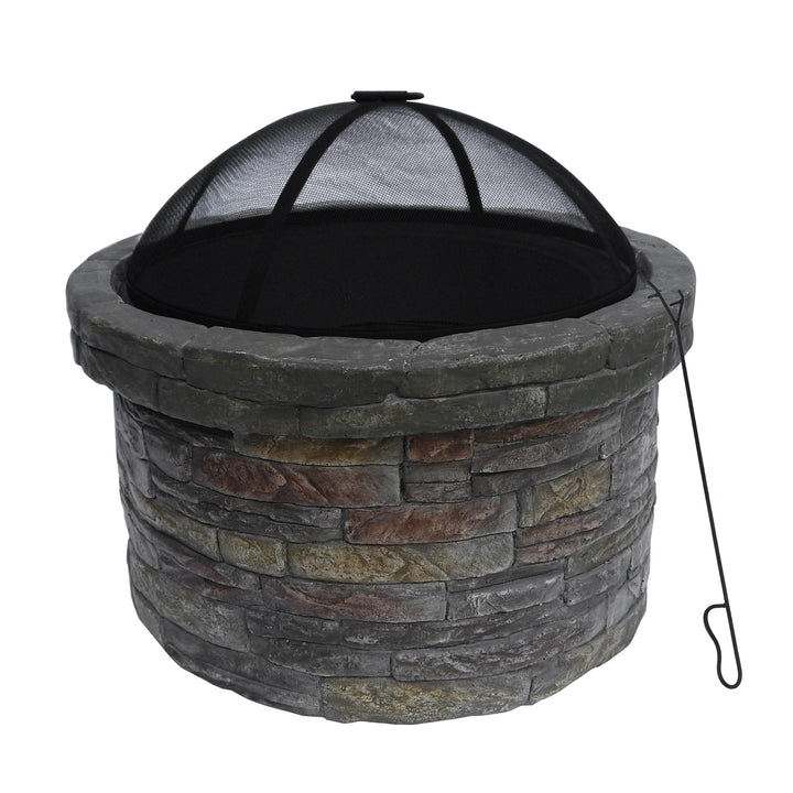 A Teamson Home 27" Outdoor Round Stone Wood Burning Fire Pit with Steel Base, Natural Stone with a mesh cover and a metal poker on the side, suitable as outdoor decor.