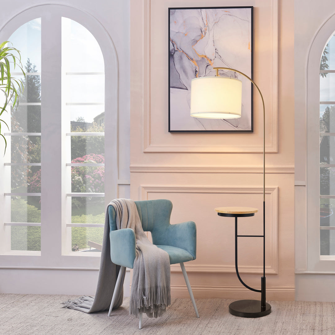 A Teamson Home Danna Floor Lamp with Marble Base and Built-In Table, White next to a blue chair in a living room