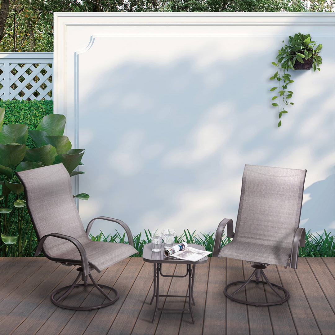 Teamson Home Outdoor 3-Piece Swivel Chairs and Table, Tan sat on a patio with a white wall