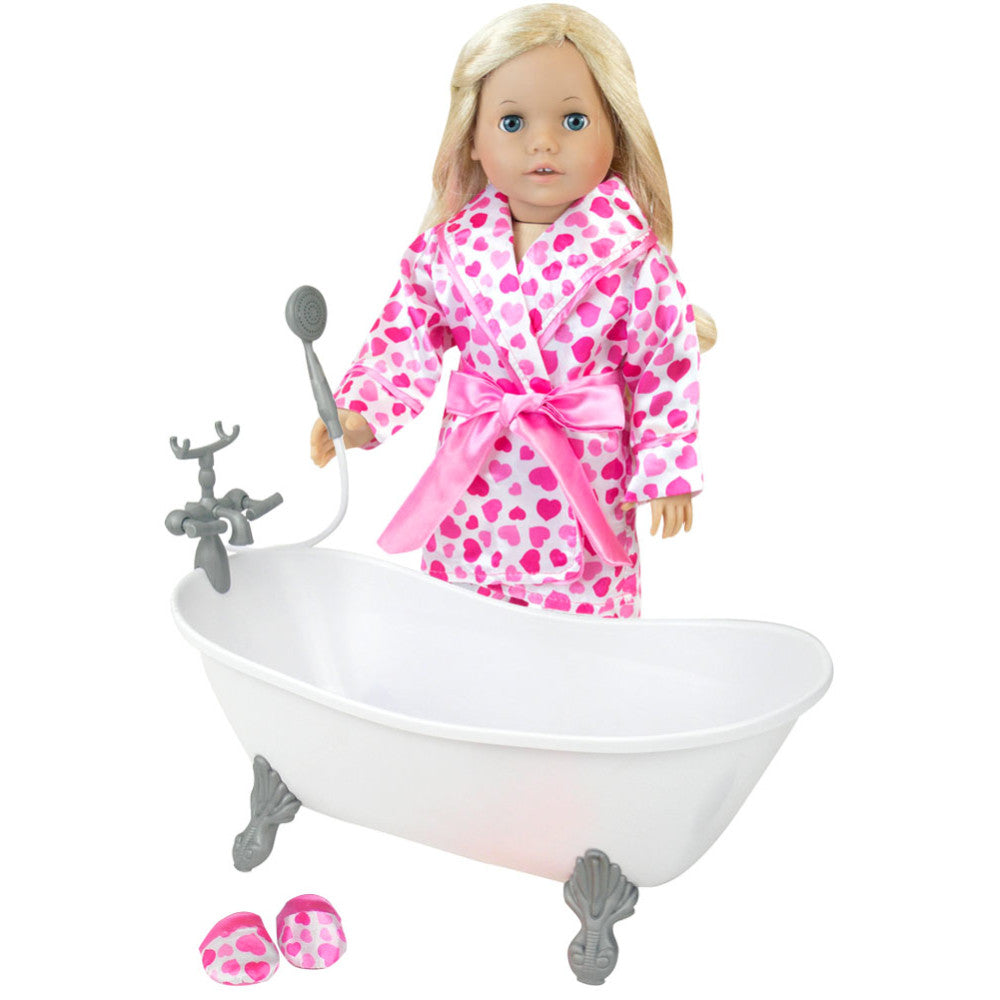 A blonde 18" doll stands next to a white bathtub with a robe with pink hearts on it.