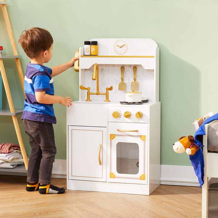 A little boy hanging the wireless phone on the side of the Teamson Kids Petite Versailles Classic Play Kitchen with Accessories, White