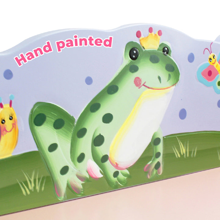 A frog is painted on a Fantasy Fields Magic Garden Wooden Bookshelf with Storage Drawers, Multicolor designed for kids' storage.