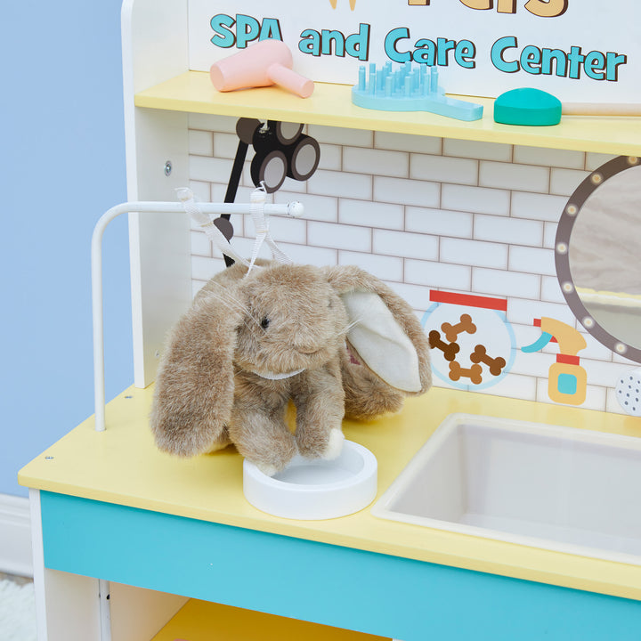 Stuffed toy rabbit sitting on a Teamson Kids Little Helper Wooden Pet Care and Veterinary Clinic Playset.