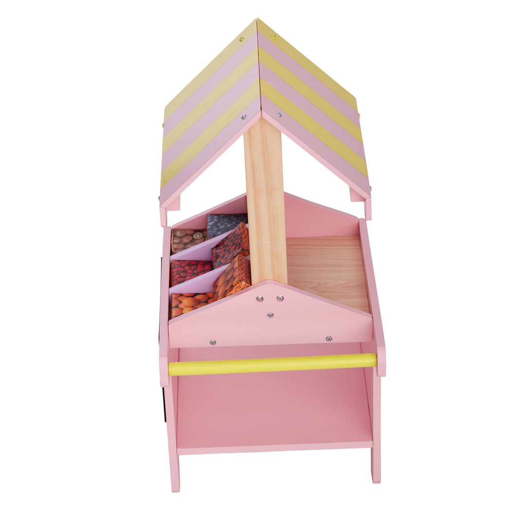A view over top of a pink and yellow fruit stand for 18" dolls with boxes of fruit.
