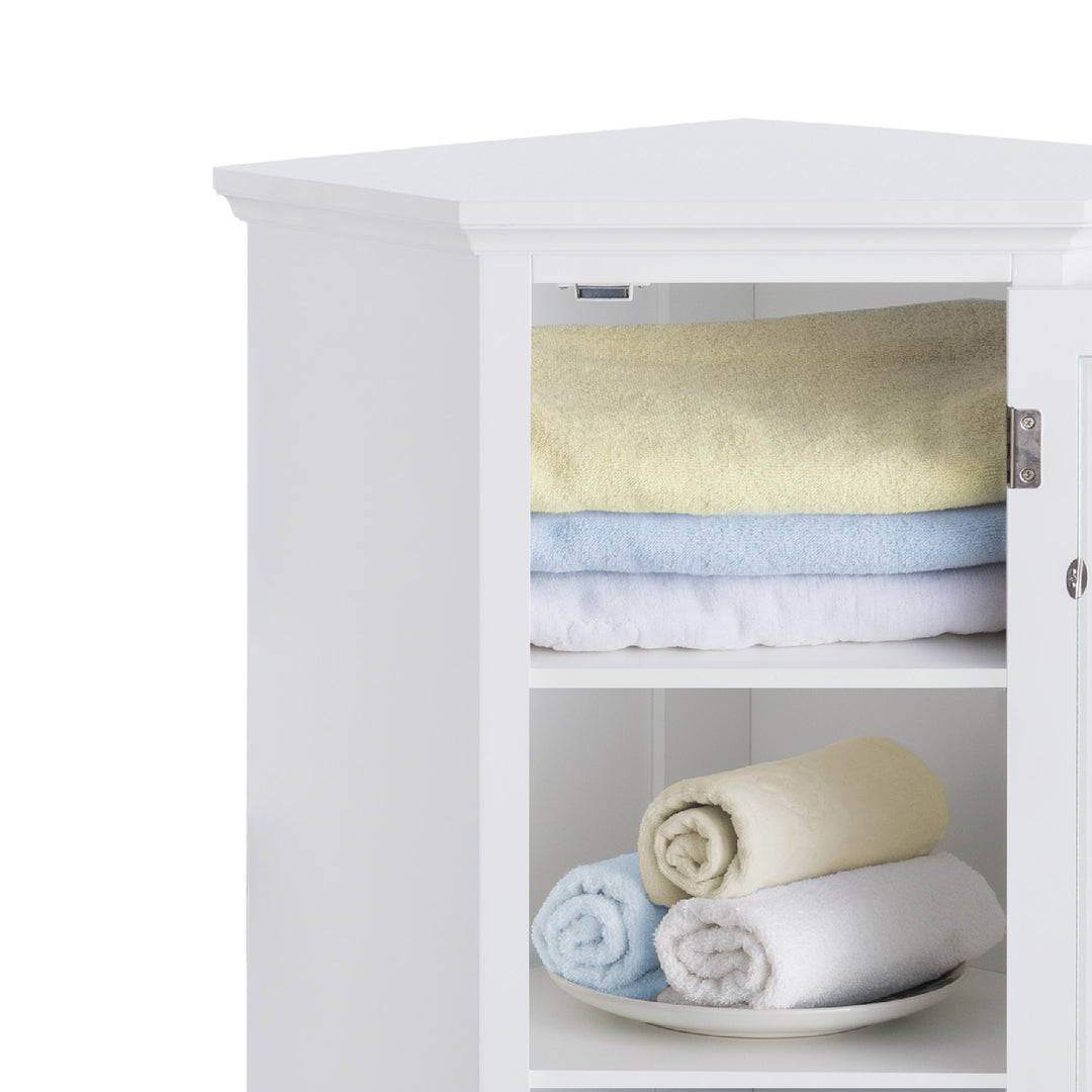 A close up of towels on the shelves inside  Teamson Home Madison Corner Floor Storage Cabinet, White