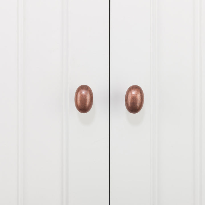 Two bronze-colored knobs on a Teamson Home St. James Wooden Linen Tower Cabinet with 2 Drawers, White bathroom cabinet door.