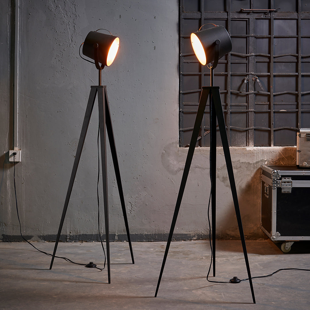 A pair of Teamson Home Artiste 62" Modern Spotlight Tripod Floor Lamps, Black with Gold Interior in an industrial styled room
