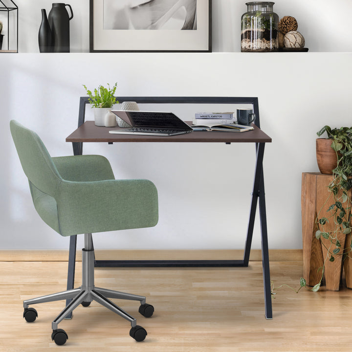 Teamson Home Folding Wooden Computer Desk with Metal Base, Walnut finish/Black in a room with a green chair.