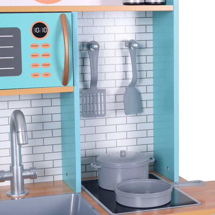 Teamson Kids - Little Chef Santos Retro Play Kitchen with a close-up of the faux tile backsplash, two spatulas, a pot and a pan.