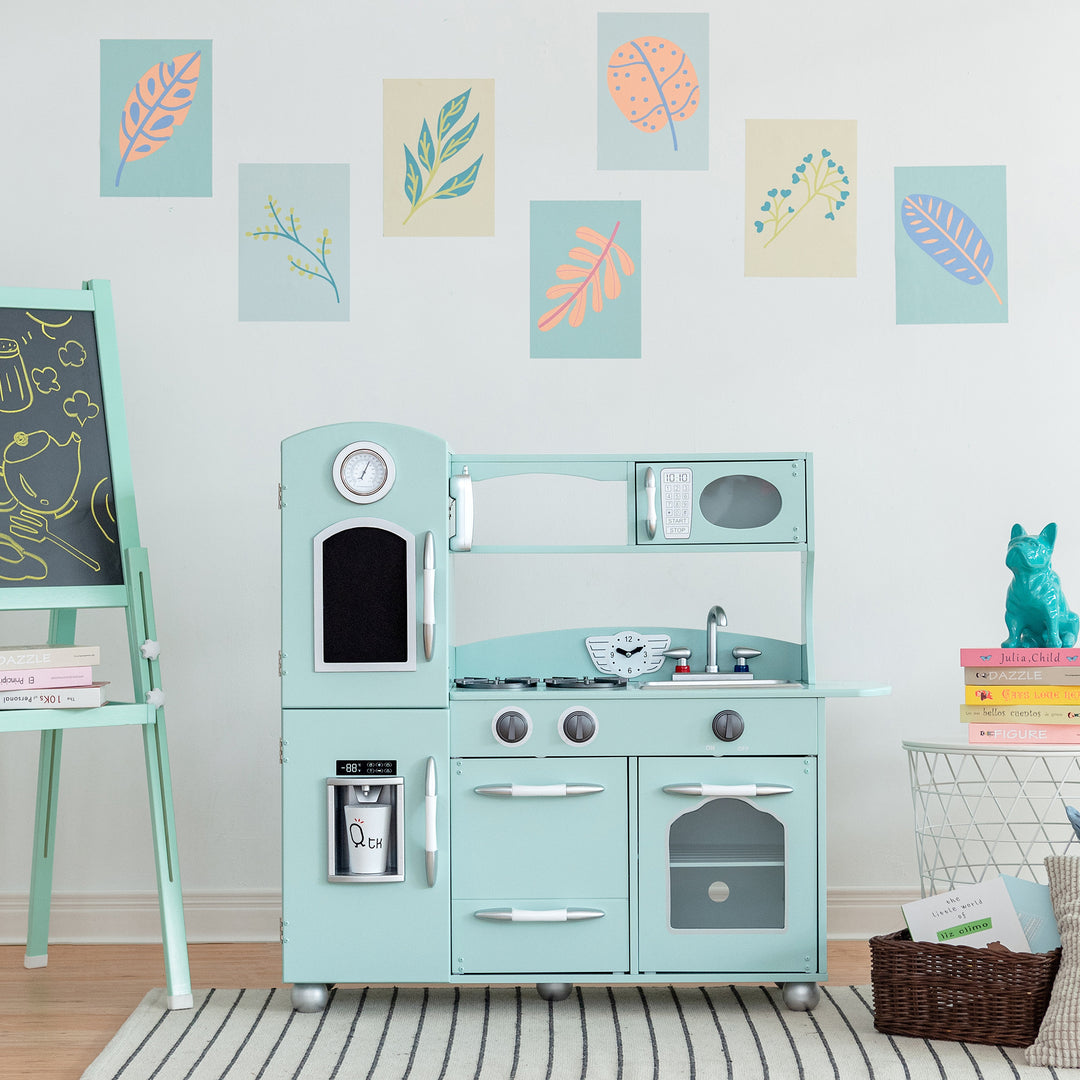 A Teamson Kids Little Chef Westchester Retro Kids Kitchen Playset, Mint with interactive features in a room with decorative leaf prints on the wall.