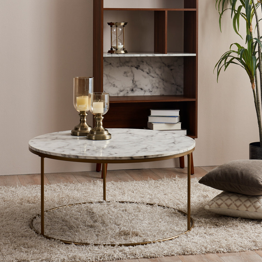 A Teamson Home Marmo Modern Marble-Look Round Coffee Table on a fuzzy rug in a living space.
