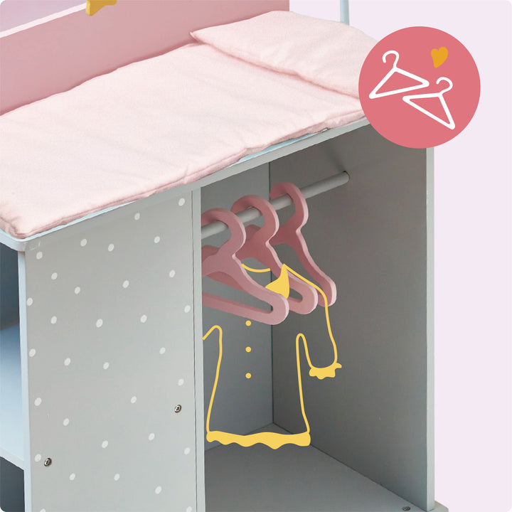A baby doll changing station in pink and gray with white polka dots with a closet.