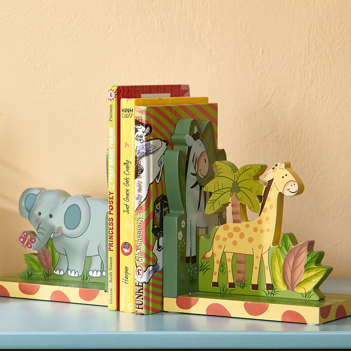A group of books, flanked by Fantasy Fields Sunny Safari Bookends, Set of 2, Multicolor, sits on a shelf as playroom organization.