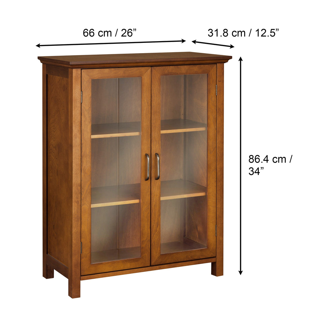 Teamson Home Avery Wooden 2 Door Floor Cabinet with Storage, Oiled Oak with glass doors and shelves, dimensions labeled in inches and centimeters