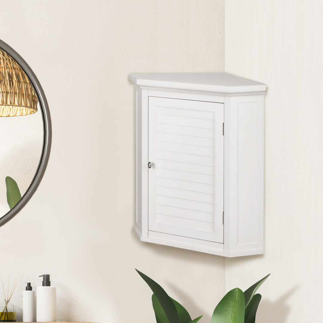 Teamson Home White Glancy Corner Wall Cabinet with Louvered Door with a mirror and plants nearby.