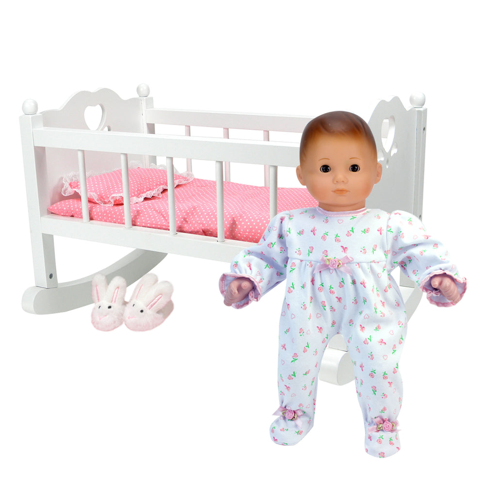 A doll in a pink pajama and Sophia's White Baby Doll Cradle Furniture Set for 15" dolls designed for pretend play.